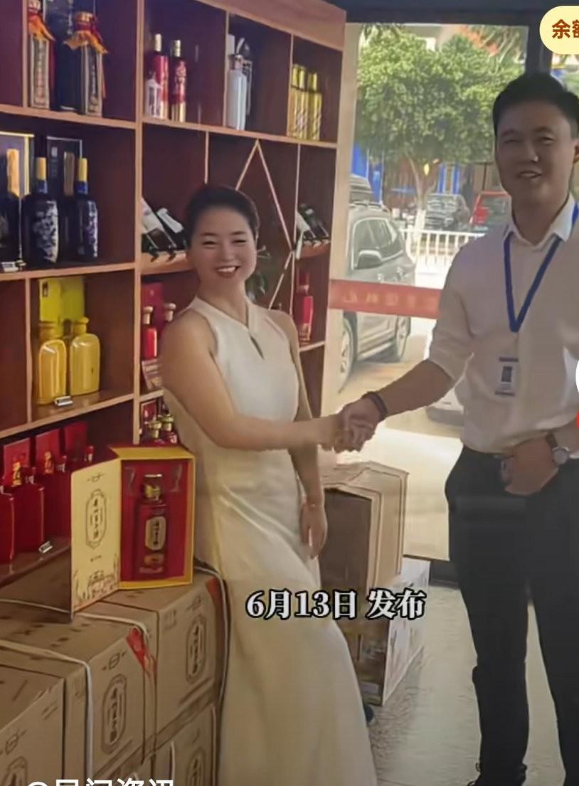 客户买酒与销售一起合影，没想到酒瓶掉落，直接砸碎在地上，
小伙眼疾手快的想去接酒