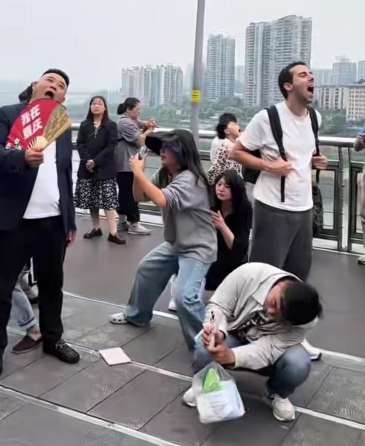 真的笑不活了！五一的重庆李子坝观景台，放眼望去全是仰头张大嘴的游客，一动不动跟按