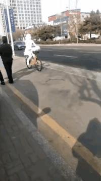 图中骑车过去的是啥？是幽灵吗？现代人都怕见光了吗？