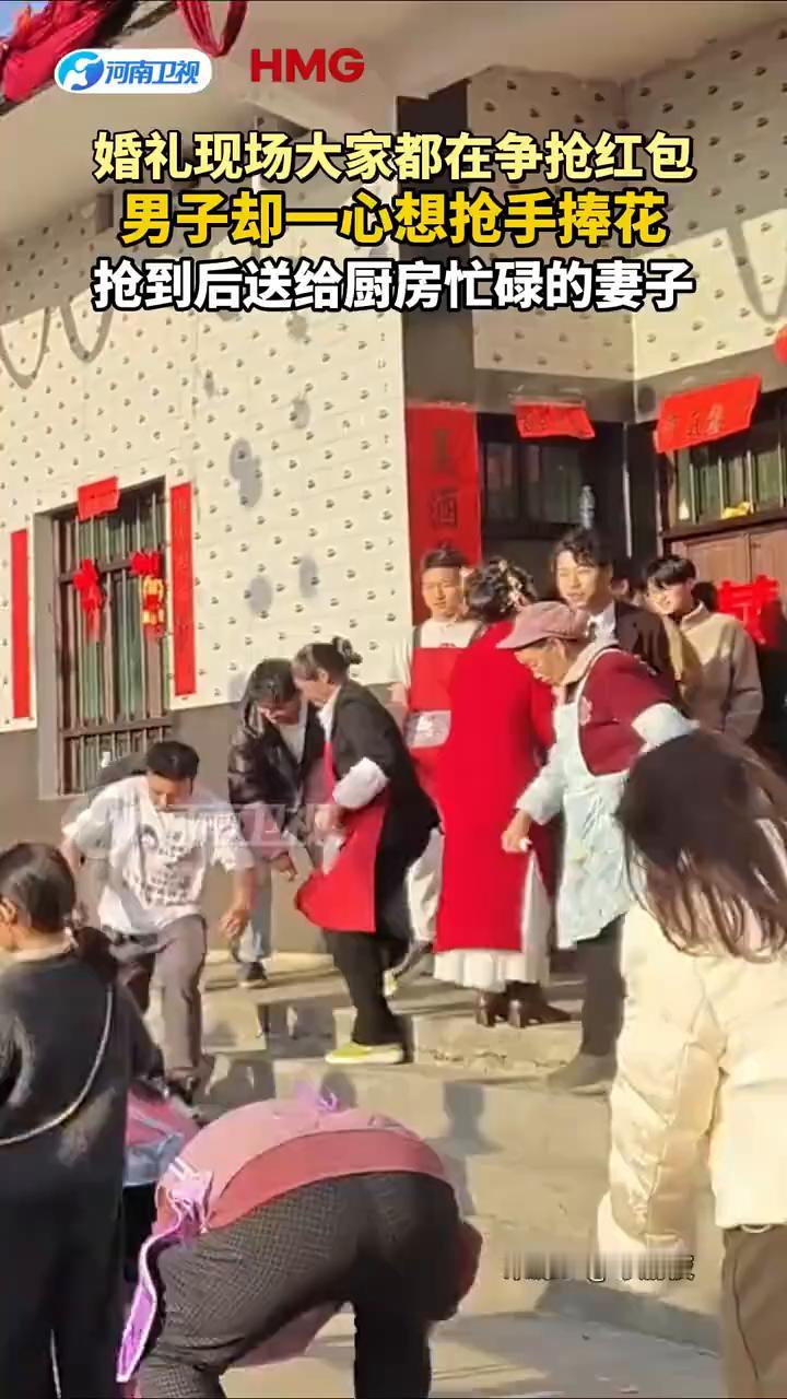婚礼现场大家都在争抢红包，男子却一心想抢手捧花，抢到后送给厨房忙碌的妻子。
来源