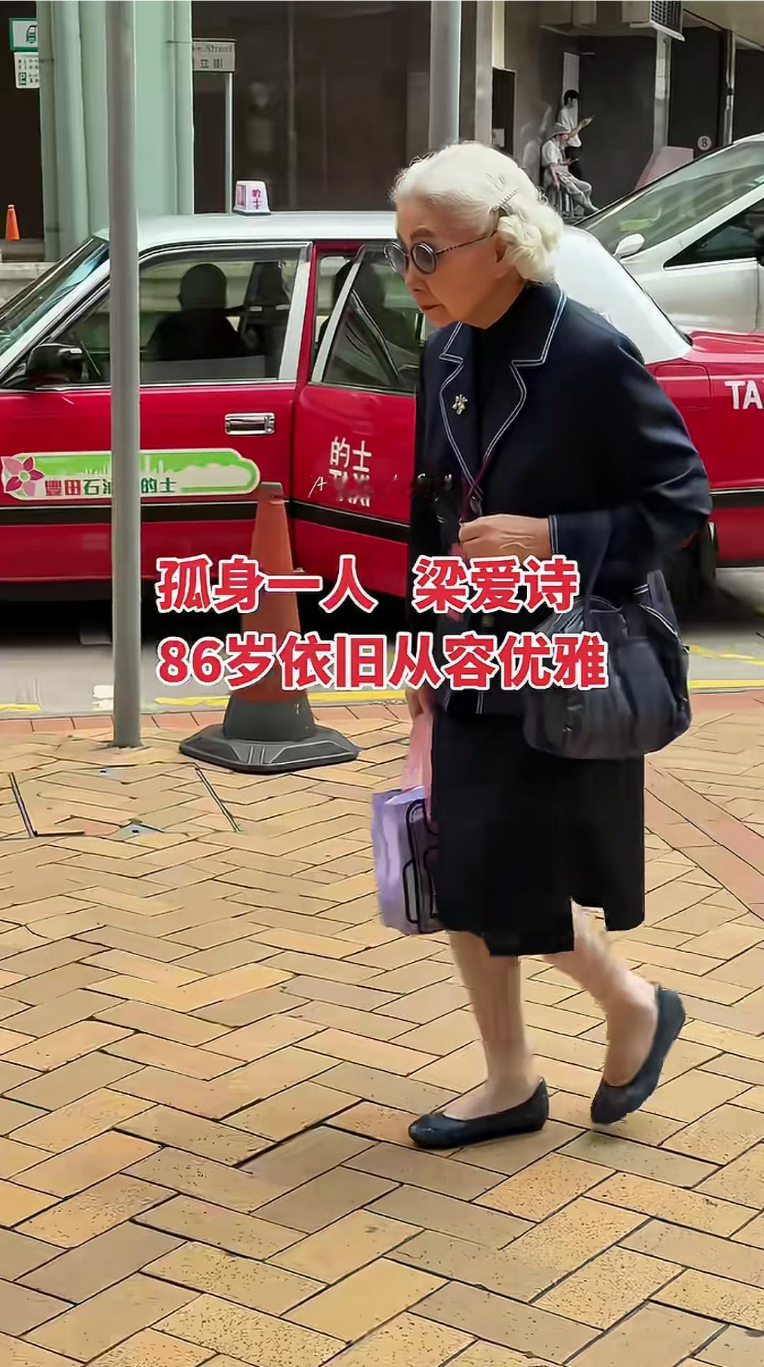 85岁的梁爱诗在港天桥被偶遇，她独自一人，没有随行人员，穿着整洁时尚，戴着眼镜，