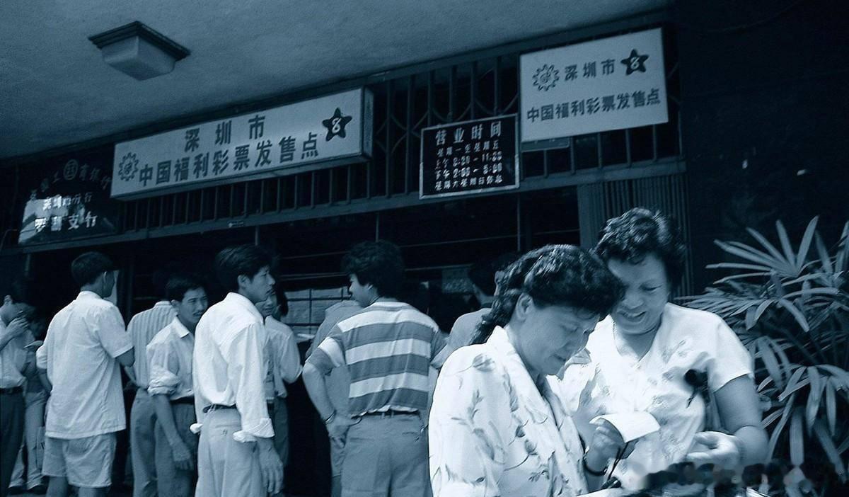 1995年，深圳一个彩票销售点外，彩民在研究彩票。 