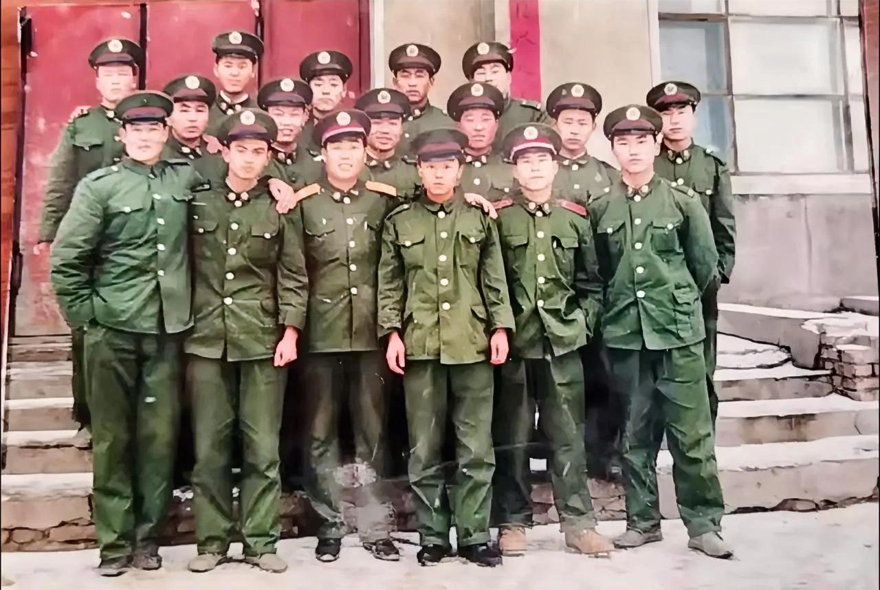 这是两名老兵退伍前的留影合照，这应该是一个排的编制，站在C位的军官是一名少尉军官