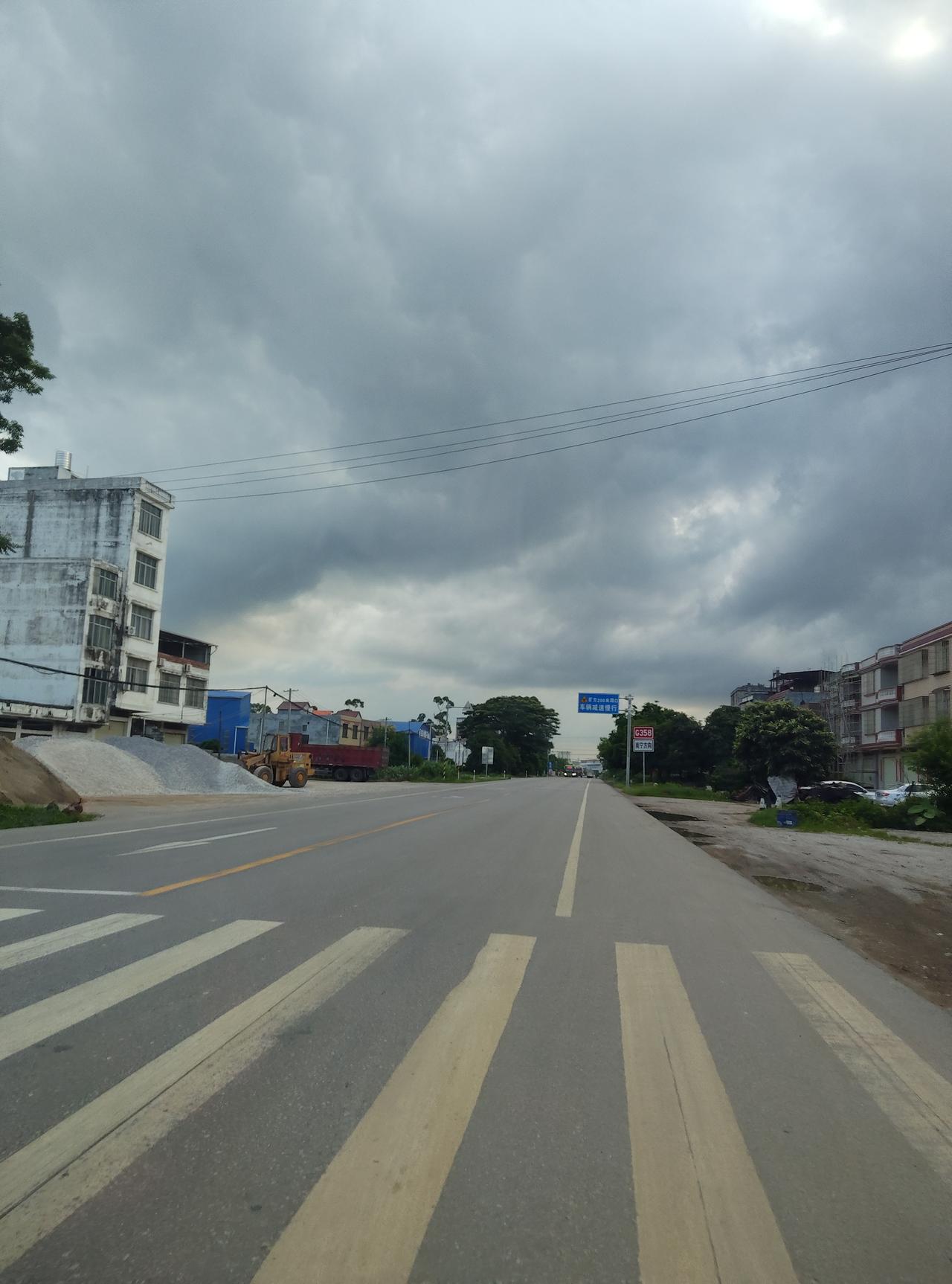看着这条路，突然觉得生活就像这天气，前一秒还晴着，下一秒乌云就压过来。但路还是要
