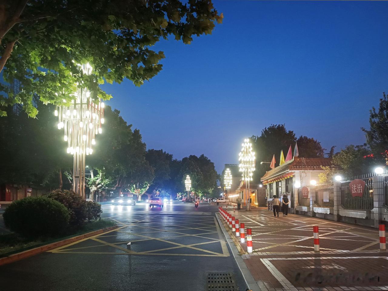 平凡小城的夜晚
——雨后路面还留着湿润水光，暮色晕开澄澈的藏蓝，造型别致的路灯依