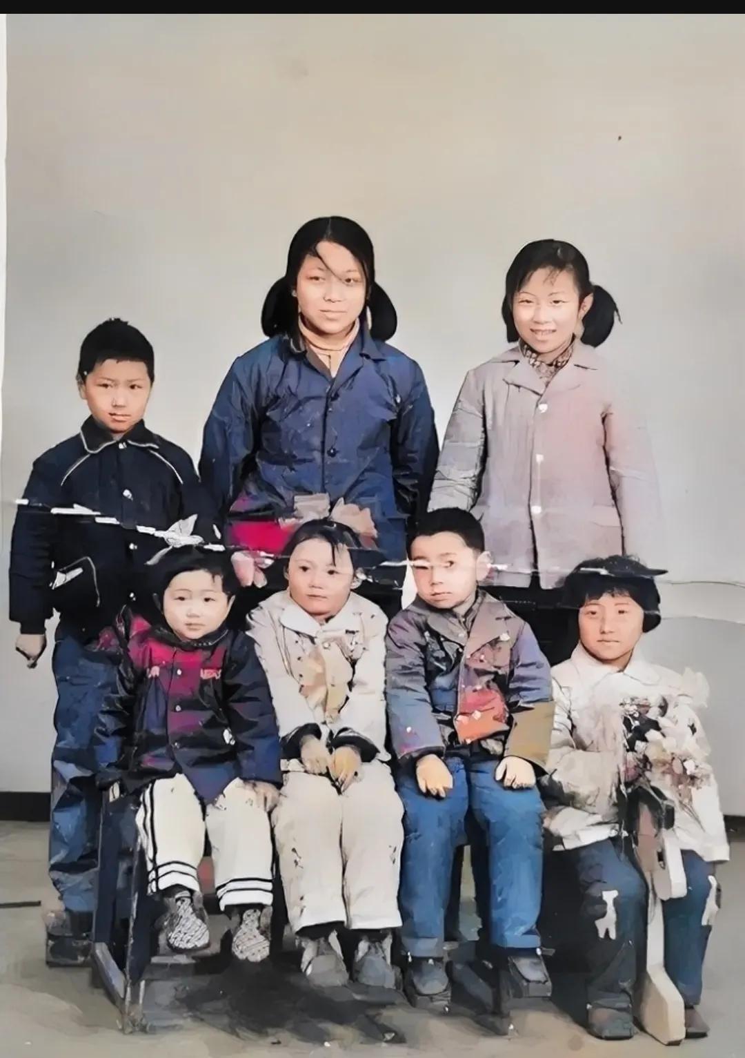 70年代初，一个普通家庭，兄弟姐妹七人的合影，照片中的大姐站在最中间，大约十四五