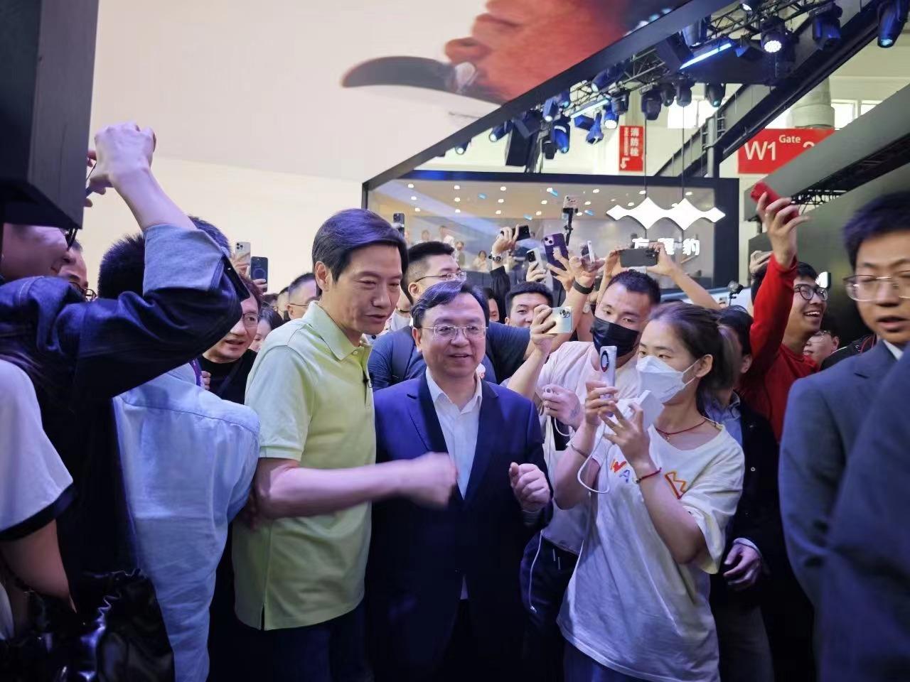 北京车展这张图，算是元素拉满了。

不仅有小米的雷军、以及比亚迪的王传福，华为也