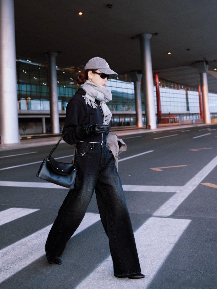 戚薇戴了皮手套 全黑look配灰色围巾棒球帽，手上那副黑色皮手套一戴，冷感氛围直