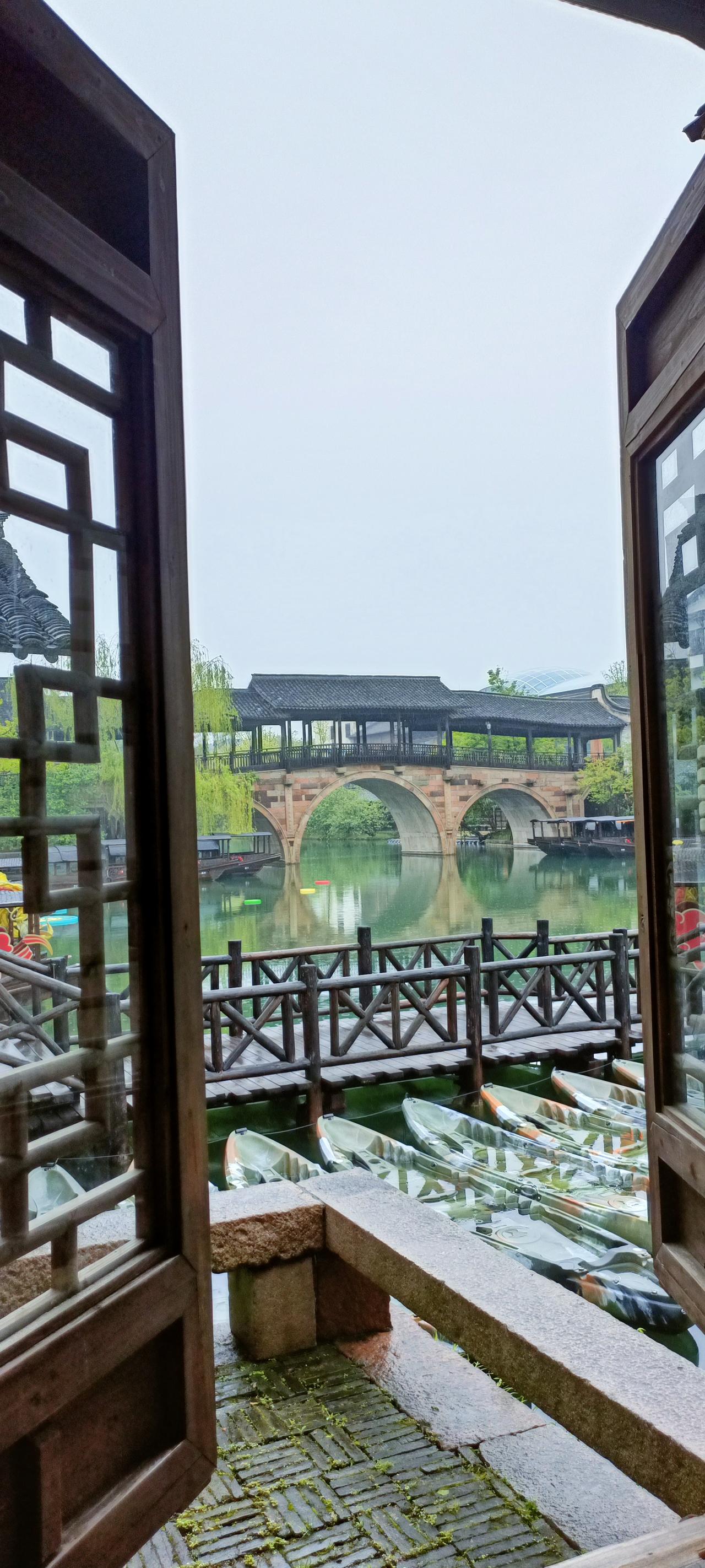 古桥流水，静谧江南，一窗一世界。
上联:桥影横波绿，
下联:楼台倒影中。