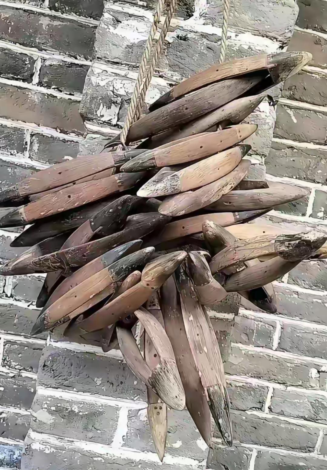 一串木挂在砖墙上。大家看看这是干什么用的吗？很有年代感。估计年轻人都不知道。