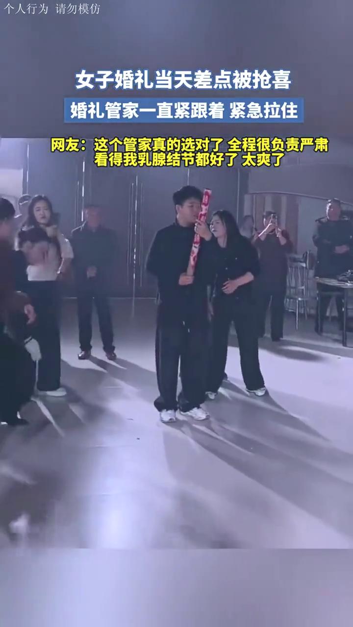 女子婚礼当天差点被抢喜，婚礼管家一直紧跟着紧急拉住。
网友：这个管家真的选对了，