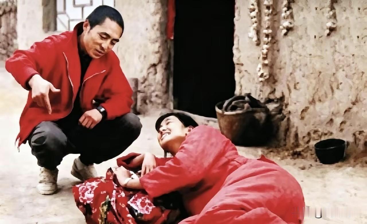 张艺谋苦讲戏，巩俐躺地随性聆听，成就金狮奖传奇。镜头下，张艺谋一身红色外套，蹲于