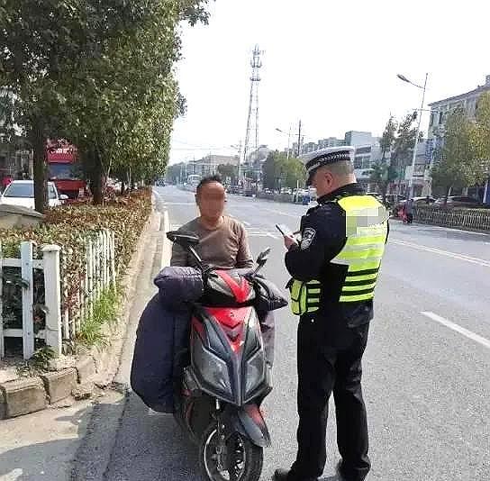 广东茂名，一位老交警在例行检查时，发现一男子骑摩托车未戴头盔。他示意男子停车接受