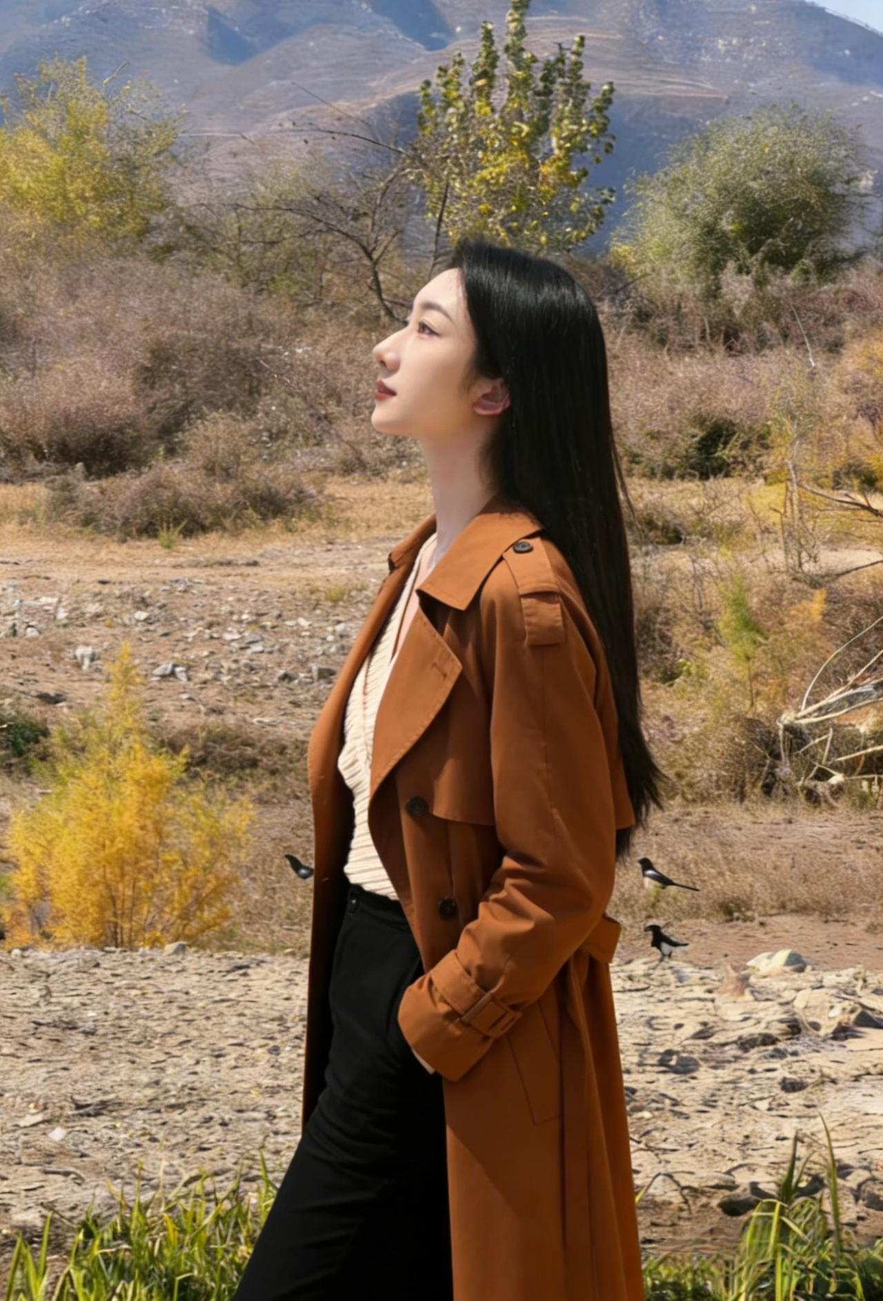目光越过枯黄的草甸
与远山的轮廓相融
焦糖色风衣裹着风
她站成，秋山的一部分