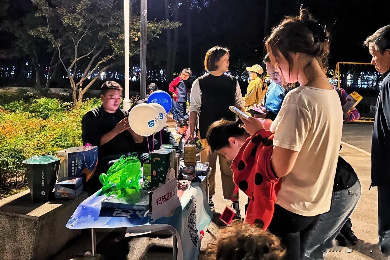 扫码送礼品～20241012常州，夜晚的五星公园里，正在进行扫码送礼品活动，这是