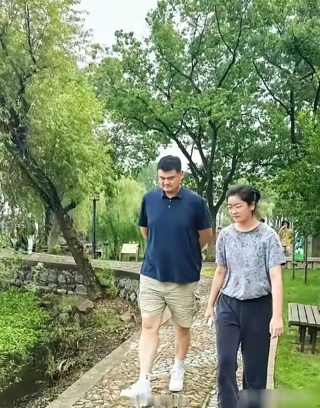 姚明与女儿一同漫步，父女俩眉眼间宛如一个模子刻出来的，神态举止也透着说不出的默契