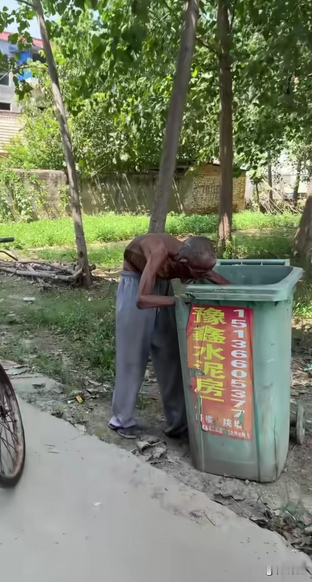 一位九十岁的老者在垃圾桶里翻找食物，他胡子又长又花白，上身未着衣物，皮肤被晒得黝