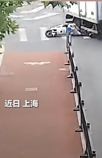 近日上海街头，一名女子骑行时被货车撞倒，整个人瞬间失去平衡摔倒在地，头部直接滑向