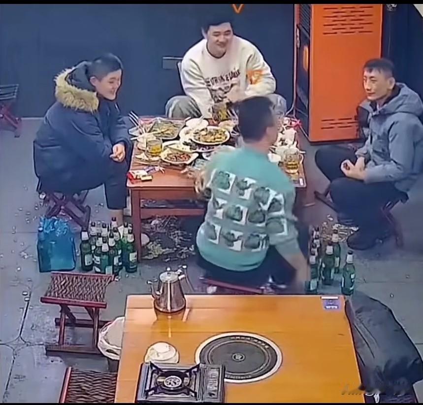 四个人在一起喝酒，一个人耍酒疯了，和他右边的男子关系可能不好，这个男子就开始装起