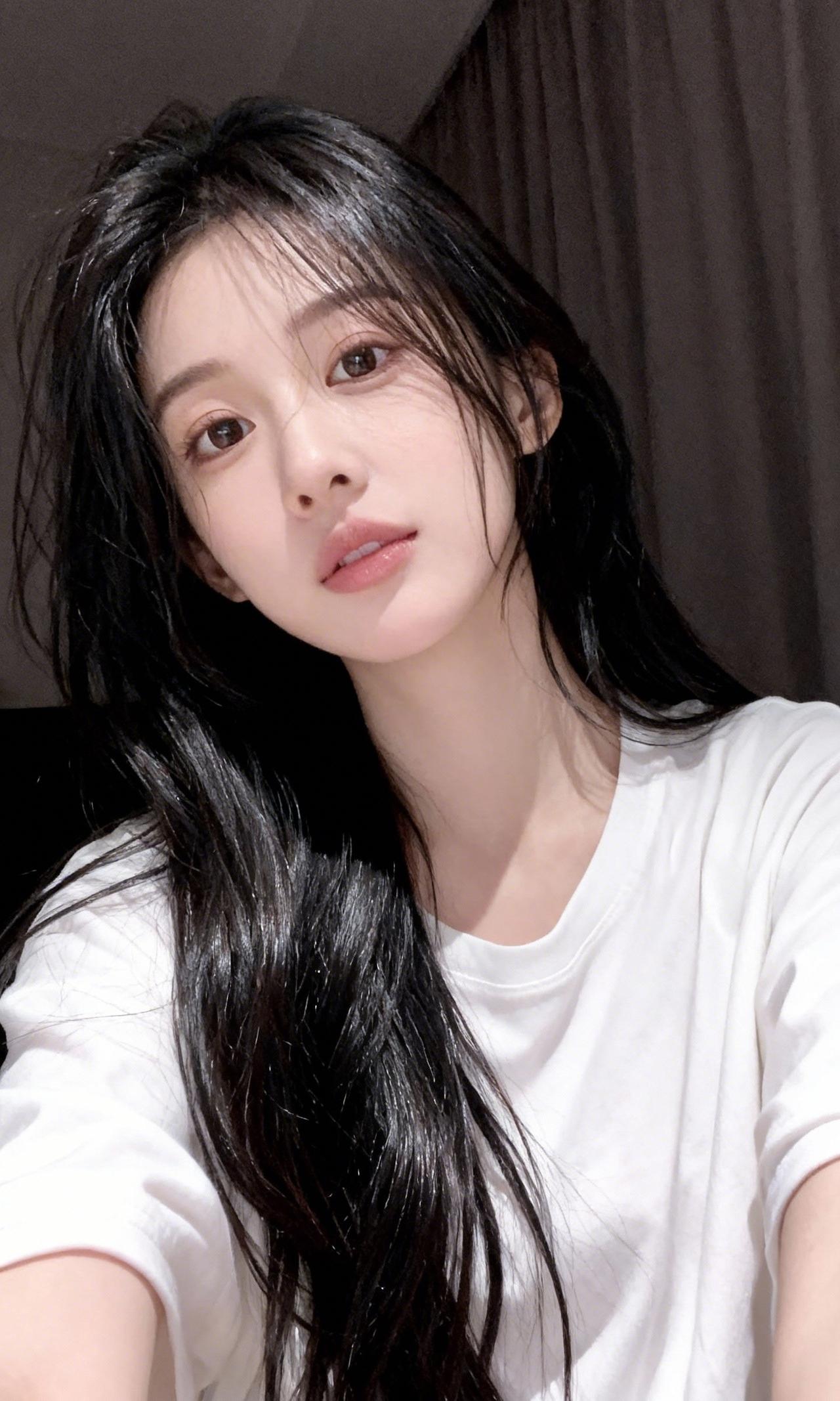 刚洗过的头发还带着潮气，
白T恤裹着松弛的晚风。
不用刻意营业，
素颜和漫不经心