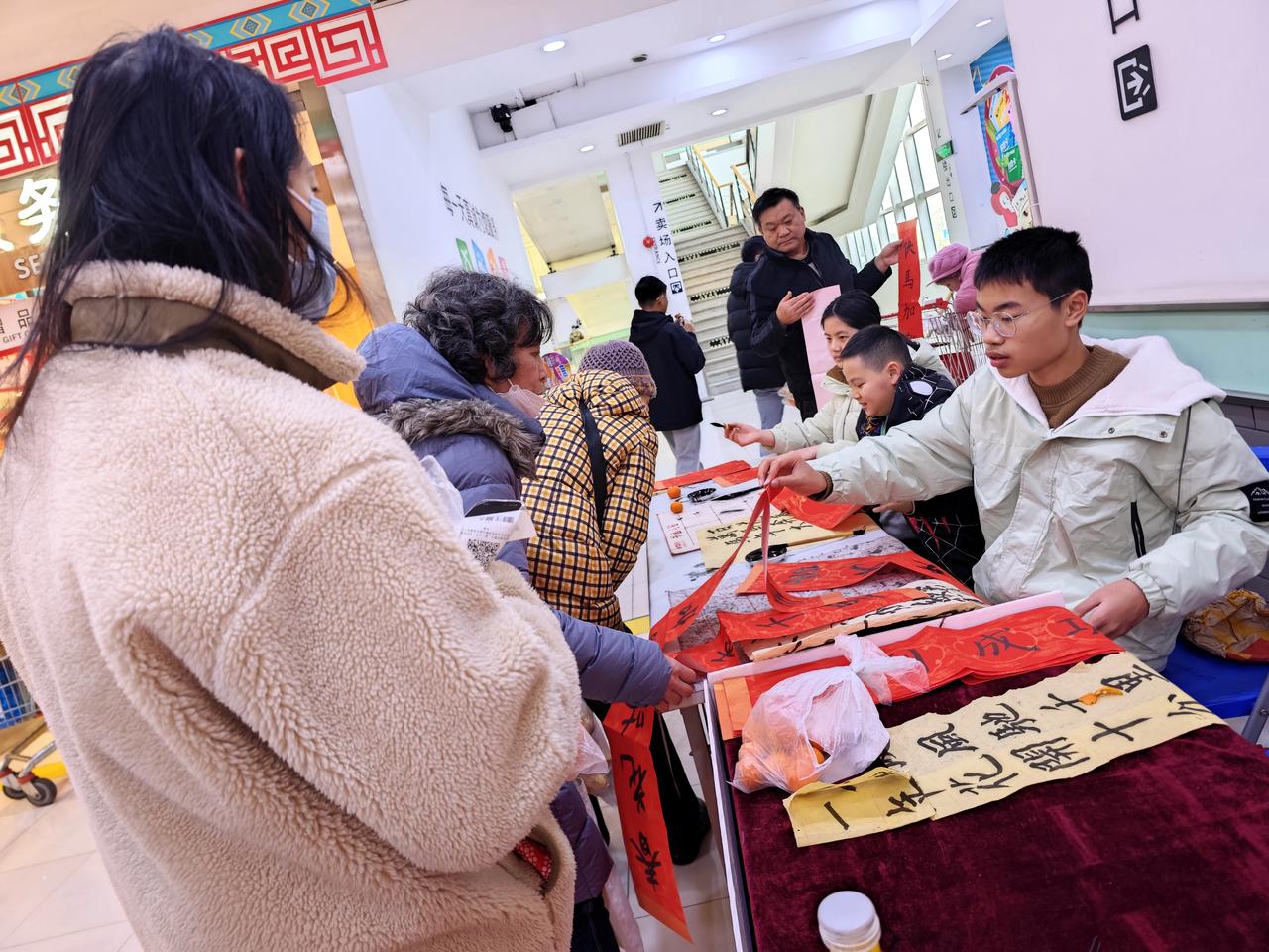 临近2026年春节，传统文化活动越来越多，钟秀文化堂的学生们在大润发写春联送福，