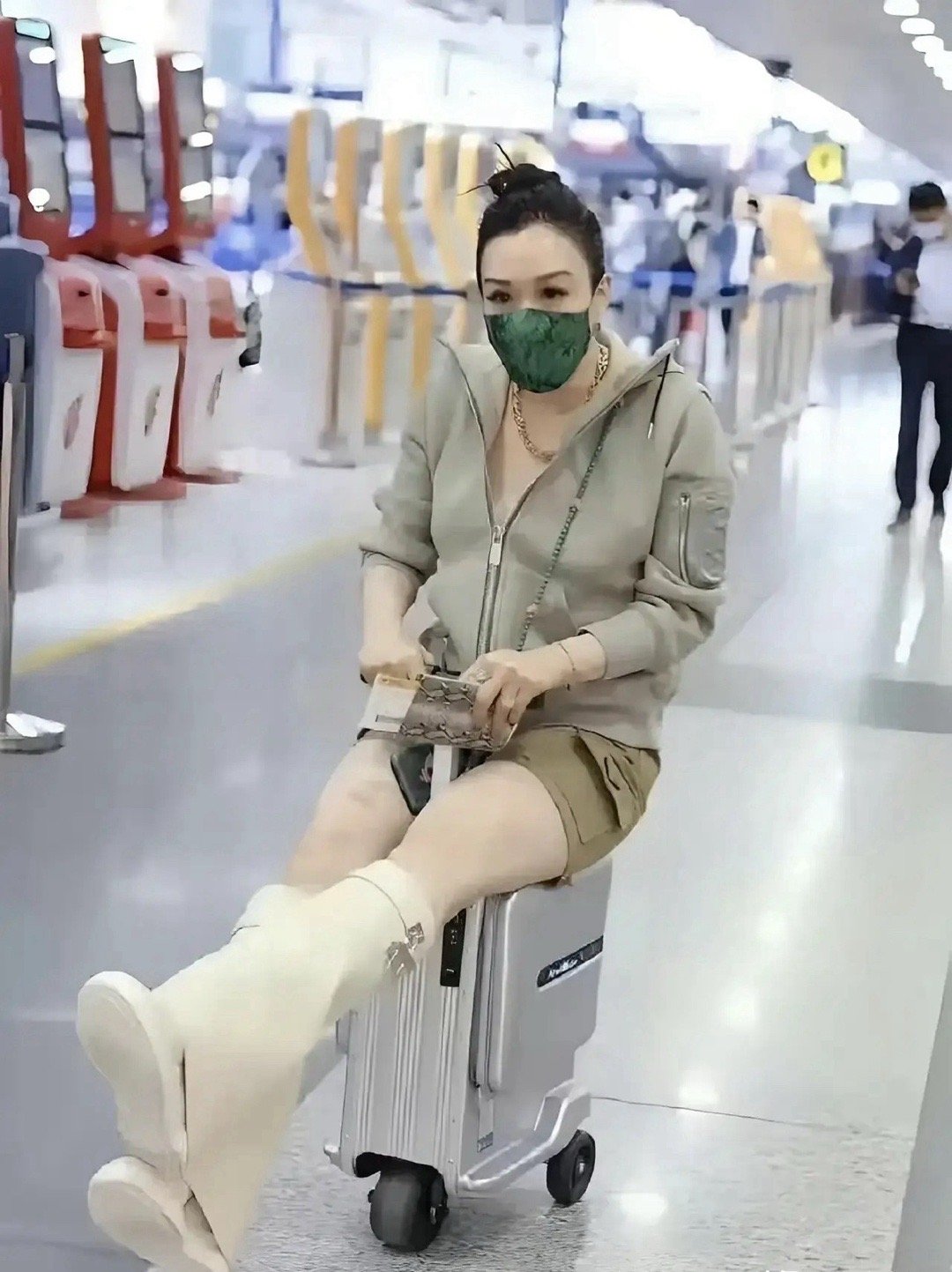钟丽缇——女人至死是少女！老牌香港女星钟丽缇机场内身穿长筒靴，小短裤，坐在行李箱