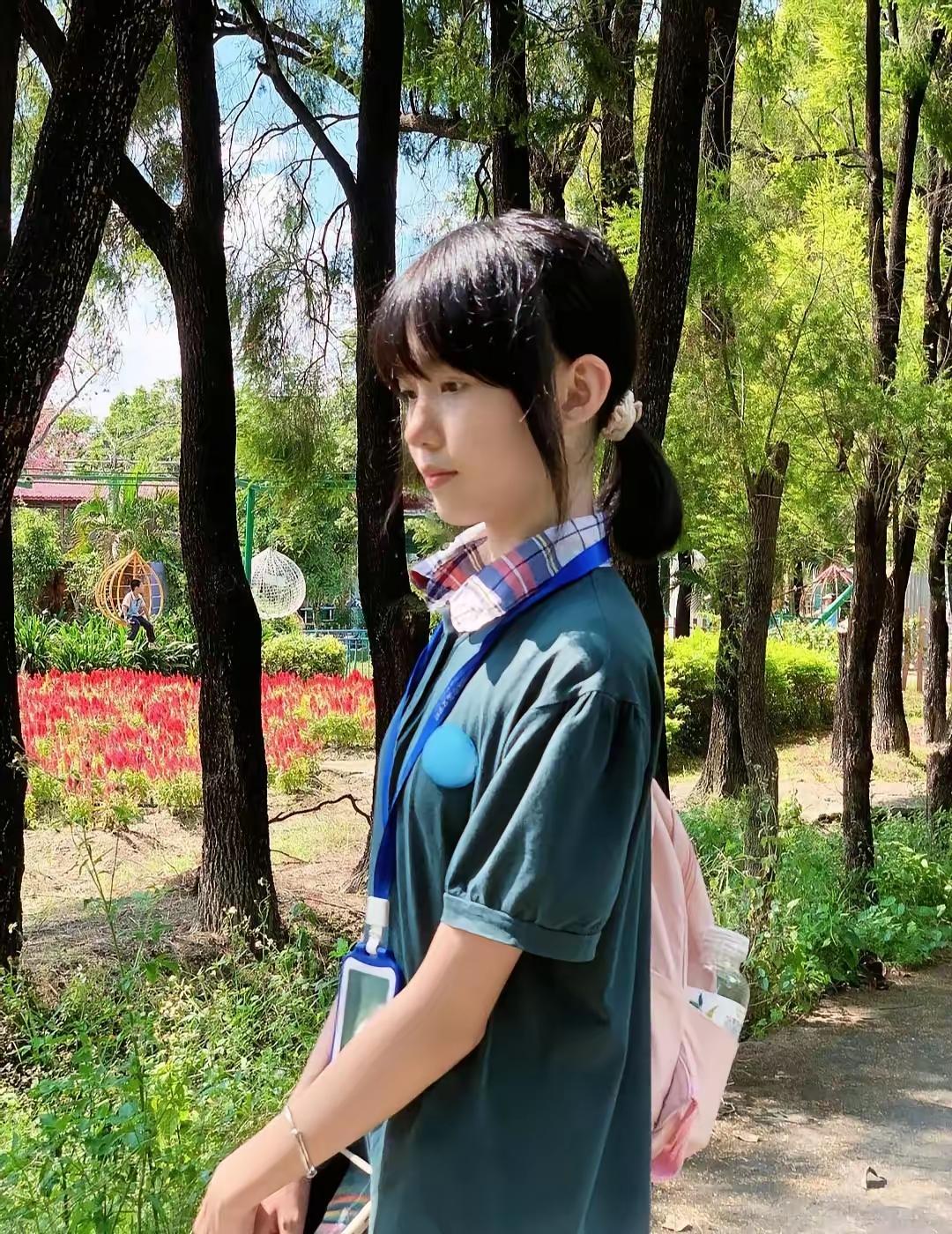 在公园里，女孩背着粉色书包。 学院风少女书包 粉色背包女孩 粉色小背包