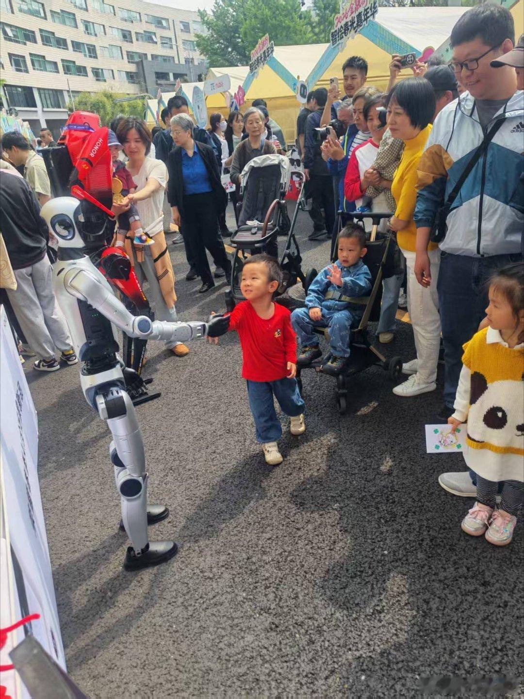 荣耀机器人夺冠后首次亮相2026金融街智绘春光嘉年华街头碰到荣耀机器人元气仔，小