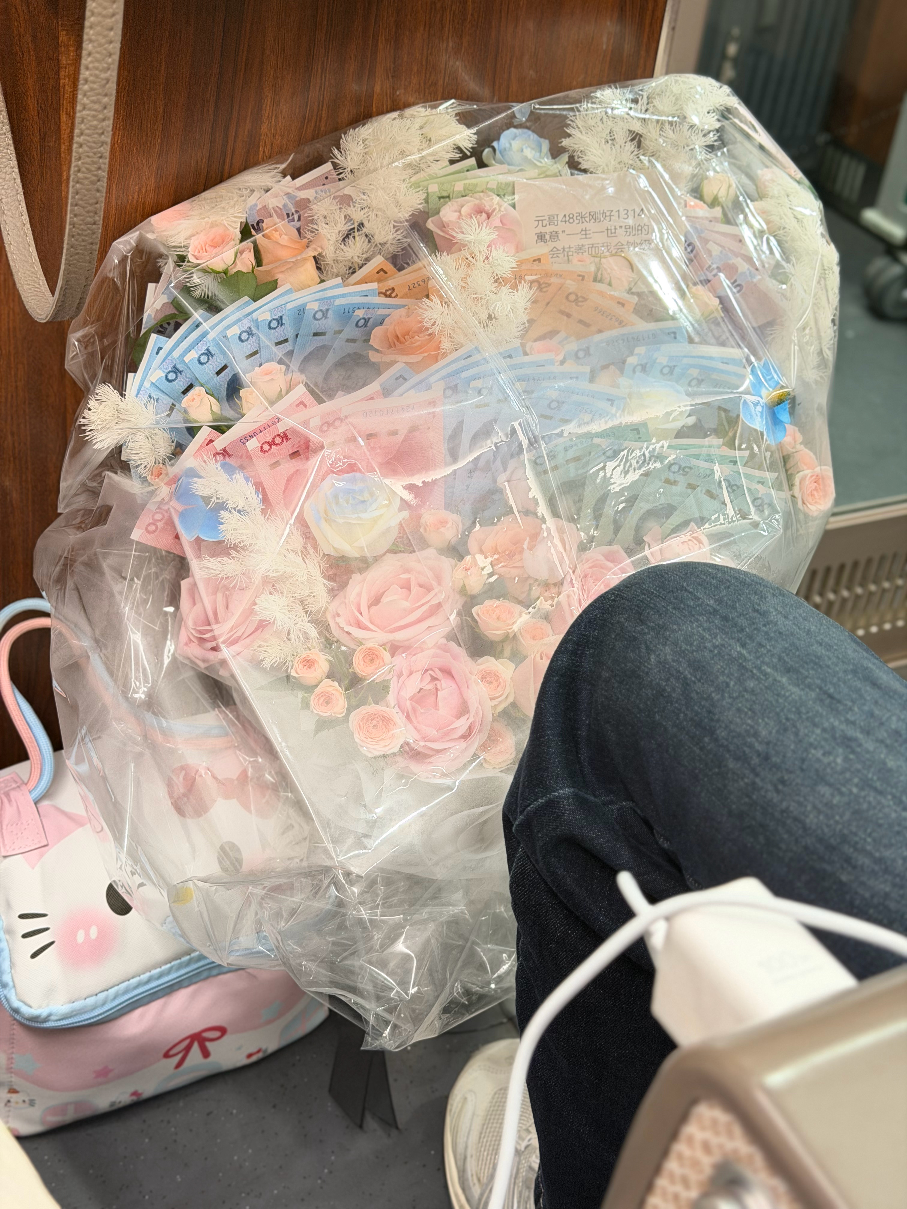 邻座上来一个女孩上车就睡着了看来是累了我马上下车了突然发现他的花上有RMB你们说