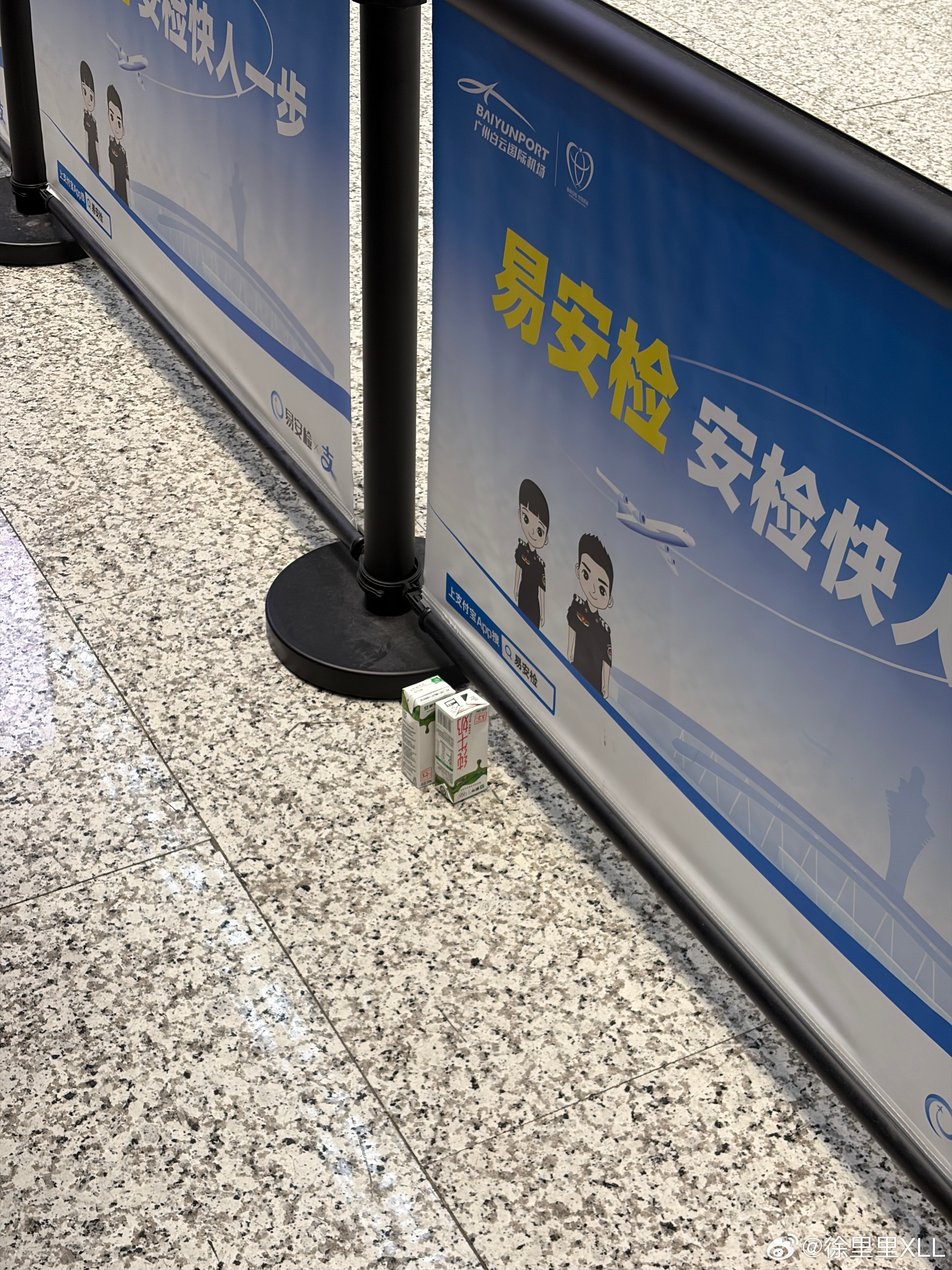 机场安检通道这里放了两盒牛奶。好想喝啊。我要是过去捡起来喝掉，会不会不太好啊？