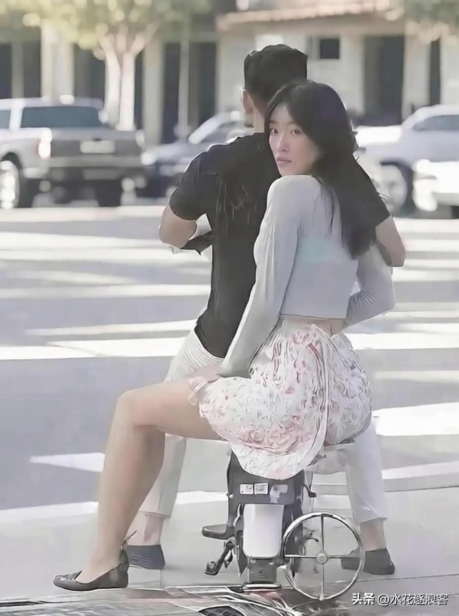 路口等红灯那一幕，真的戳中了好多普通人的心。

姑娘坐在电动车后座，扭着头盯着旁