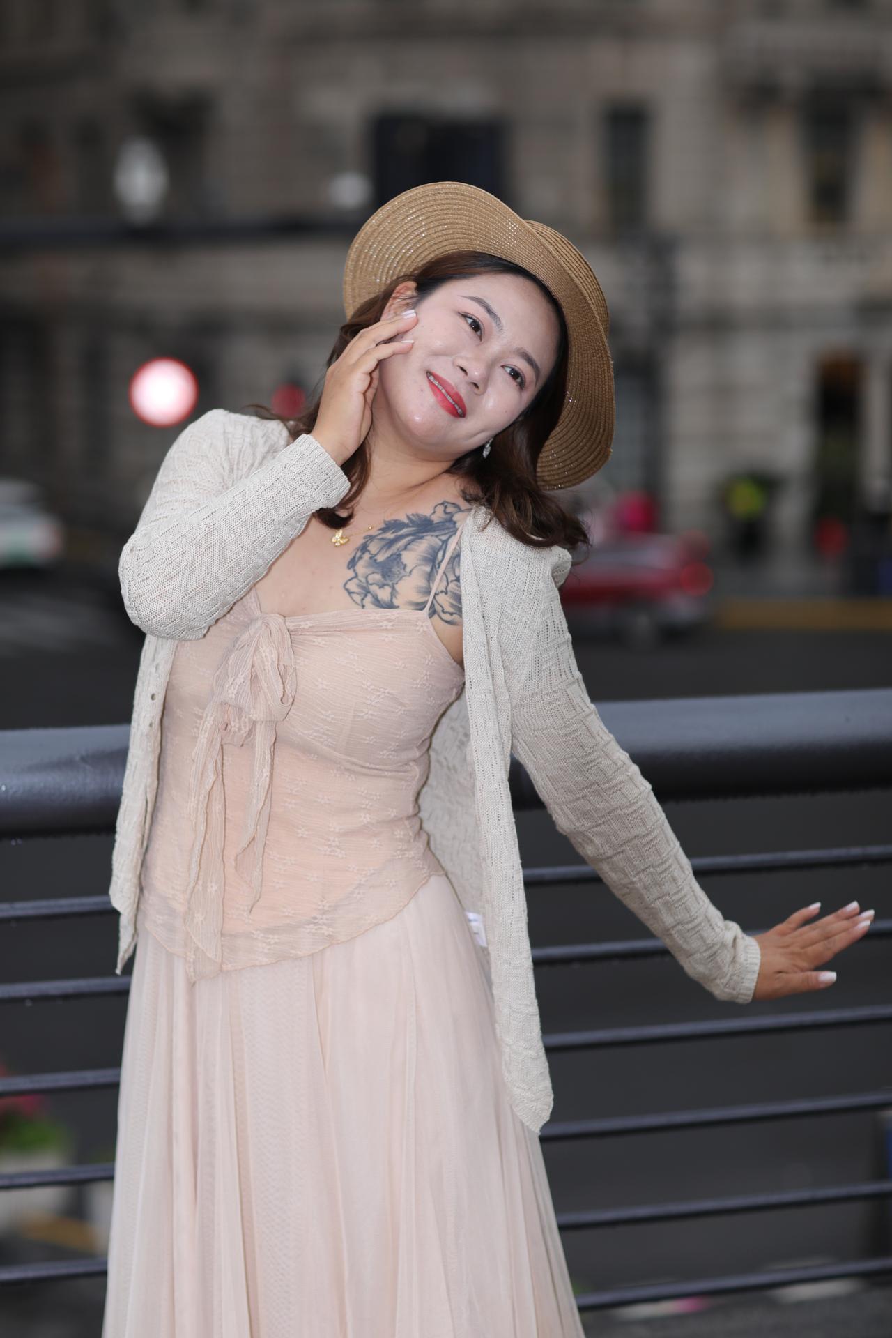 《晚风与她的浅粉暮色》

暮色漫过旧栏杆时，浅粉纱裙的柔影正与晚风相拥。米白针织