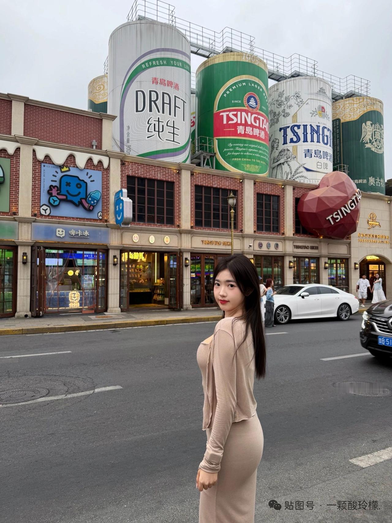 美女站在啤酒广告前，拍照打卡。