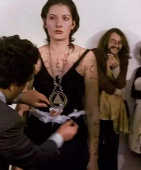 1974年意大利，一名女性赤身裸体暴露在众人面前，有人用刀划她的身体，甚至还有人