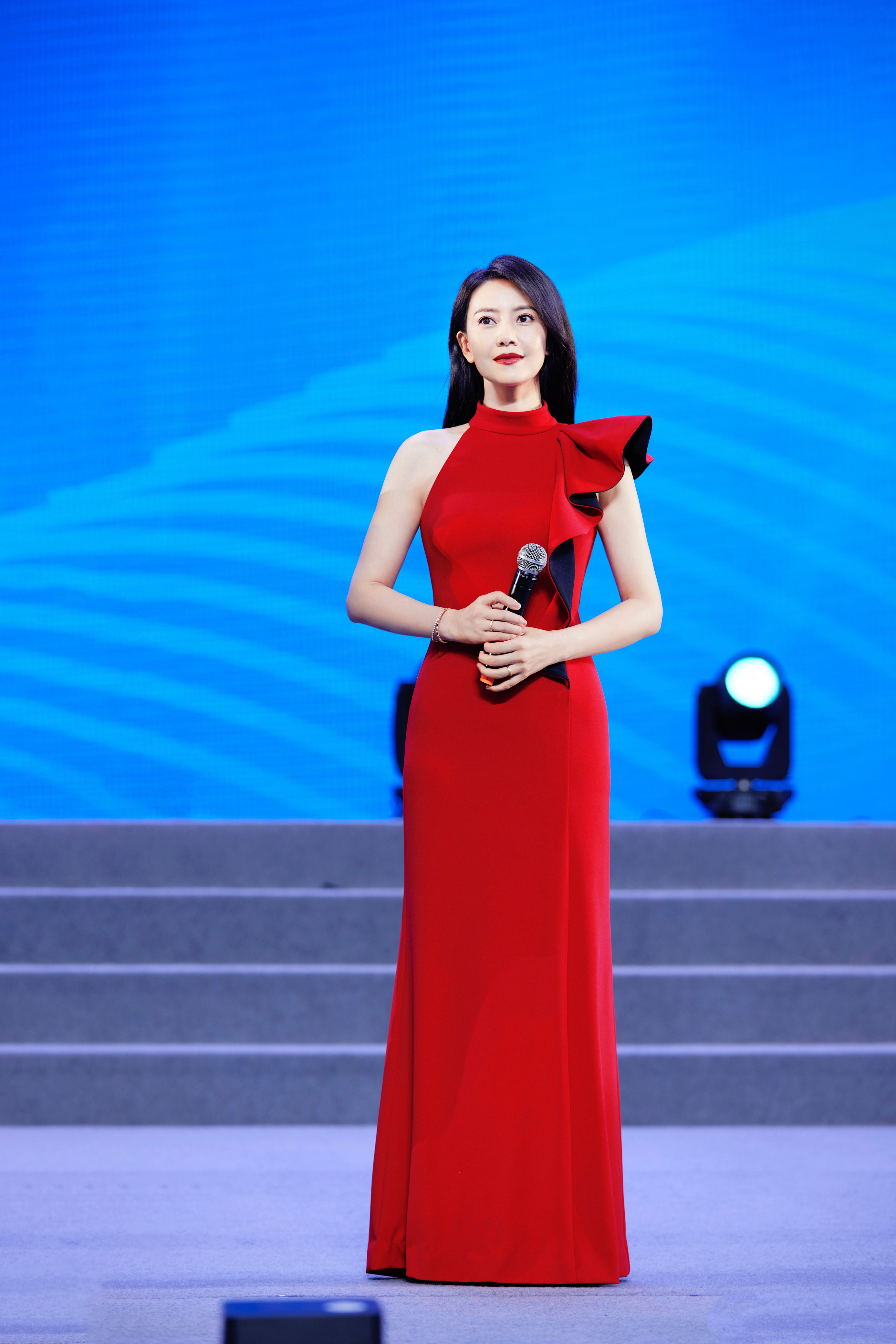 早上好☀️！一袭正红色挂脖长裙衬得她明艳大气，单边荷叶边设计增添了灵动细节，修身
