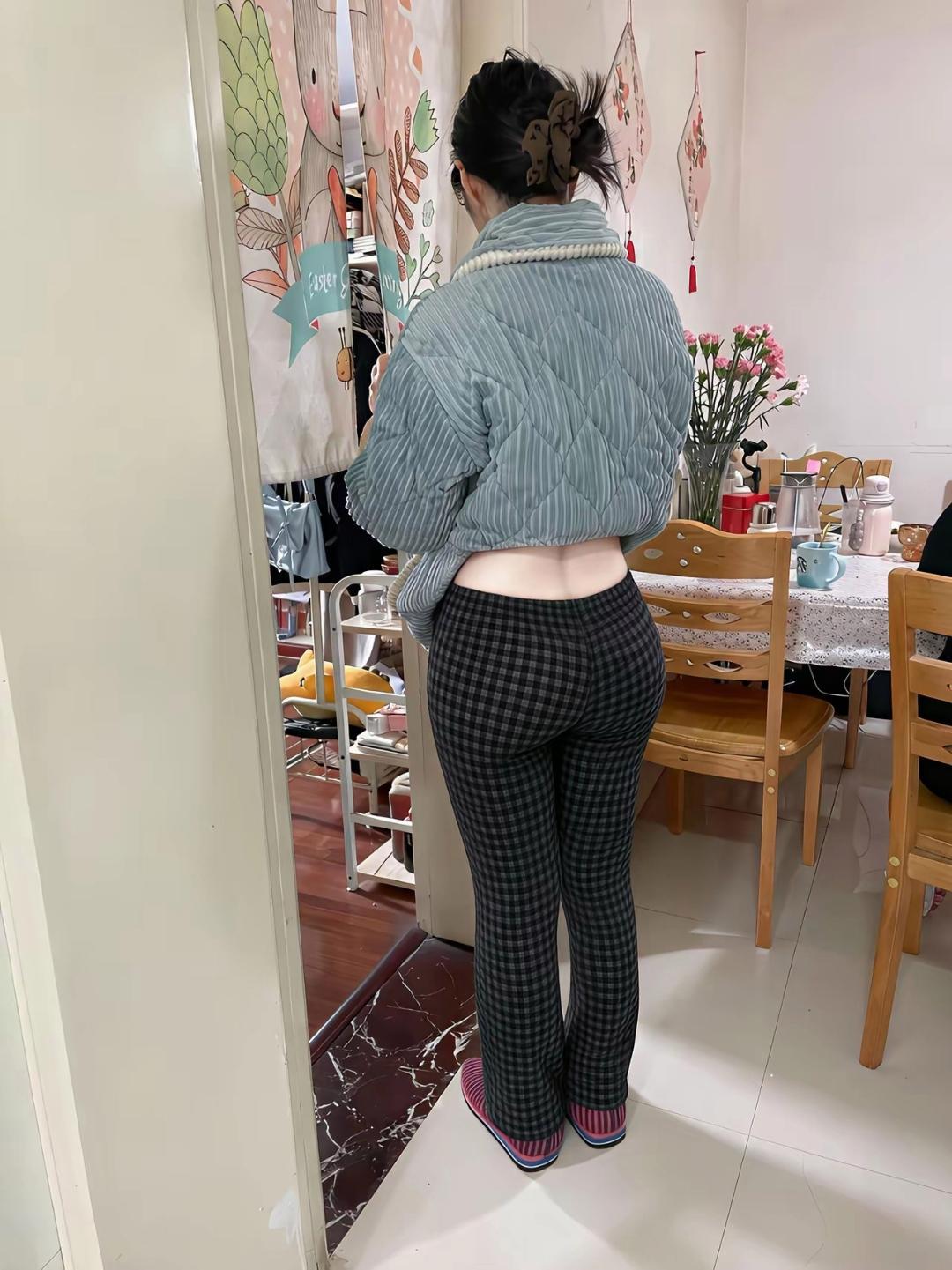 一个人站在门口，穿着时尚的套装。