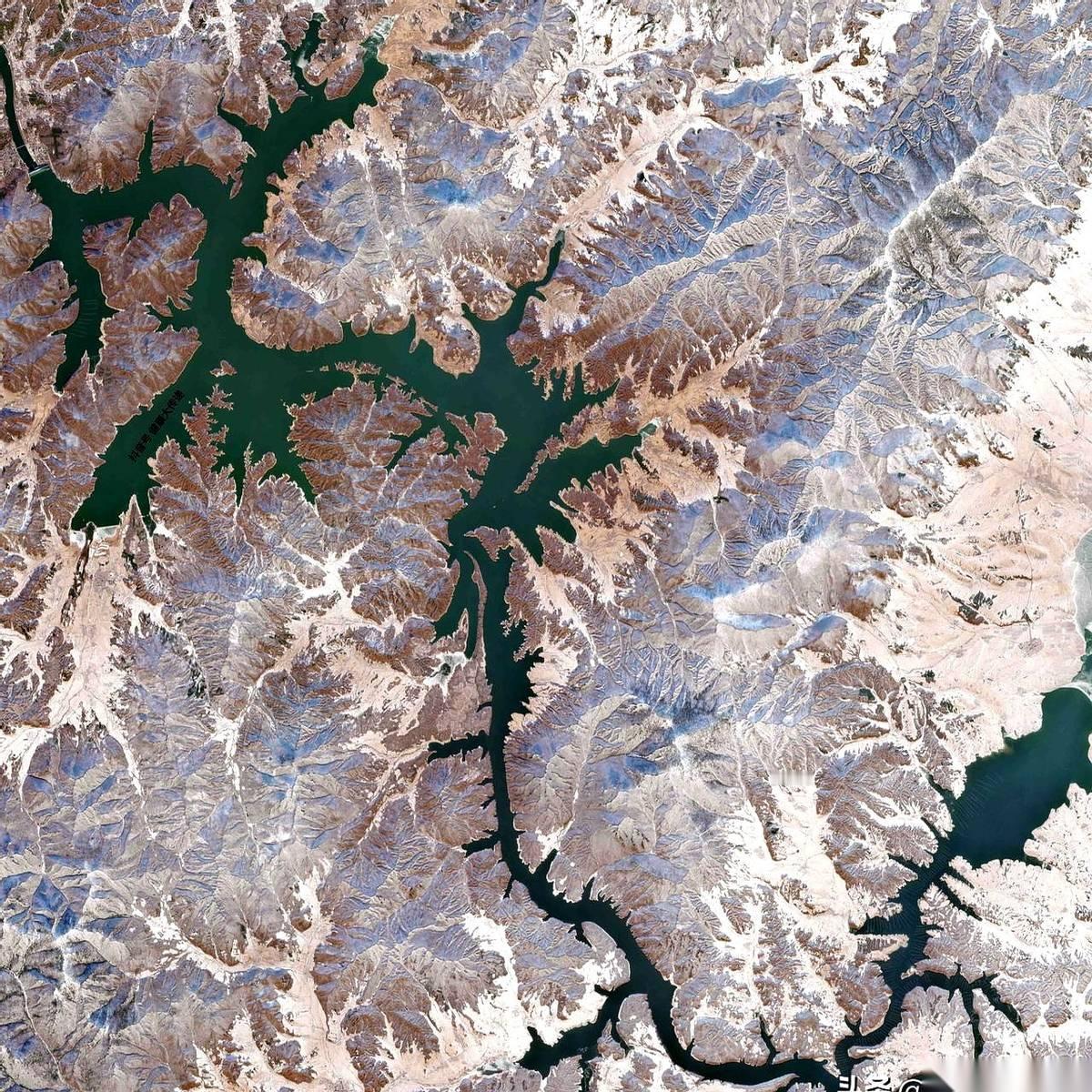 从几百公里高的天上看下去，世界安静得只剩下一幅画。
松花江冻成了一条玉带，蜿蜒着