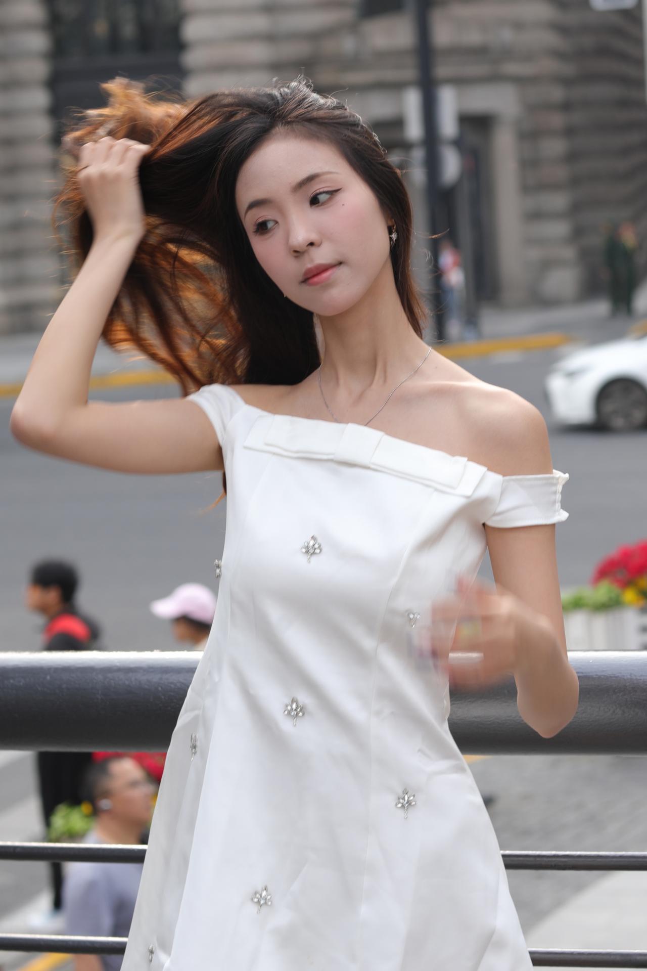 城市微光里的少女
白色缎面连衣裙上的银饰，在午后的阳光下细碎闪光，像落了一身温柔