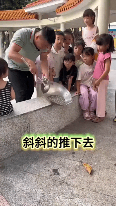 师傅细心教孩子们翻炒手艺，斜斜往下推，翘斜着往后拉，加快速度顺势一带。小朋友们团