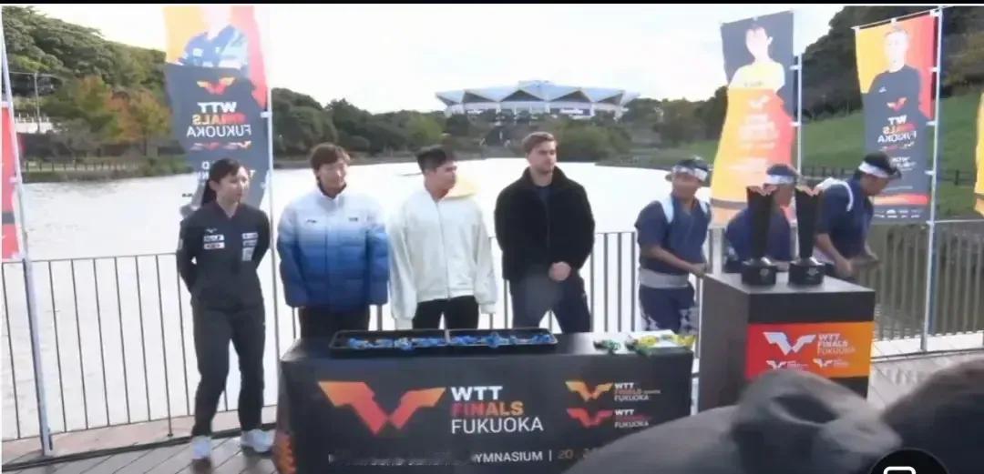 WTT福冈总决赛的抽签现场简直简陋到不行，室外抽签，冻得选手们瑟瑟发抖。王曼昱穿