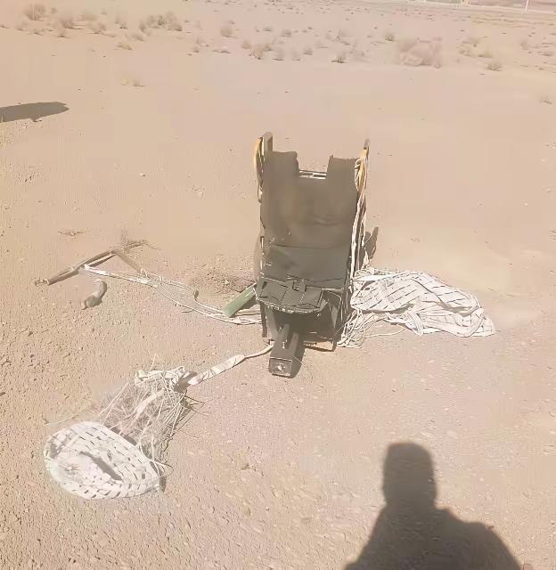 这是一个散落在沙漠地带美军F-15E战斗机飞行员紧急跳伞落地的座椅，飞行员有没有