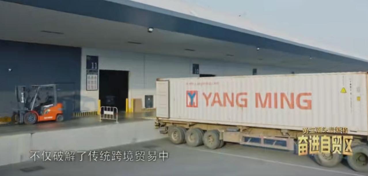 江苏自贸试验区连云港片区的物流枢纽内，集装箱卡车穿梭往来，装卸设备高效运转，跨境