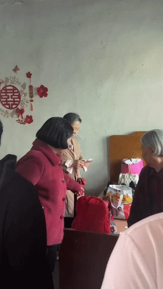 新娘母亲站在床边正在数钱？
而新娘子则一脸尴尬的坐在一边，有点不知所措！
知道的