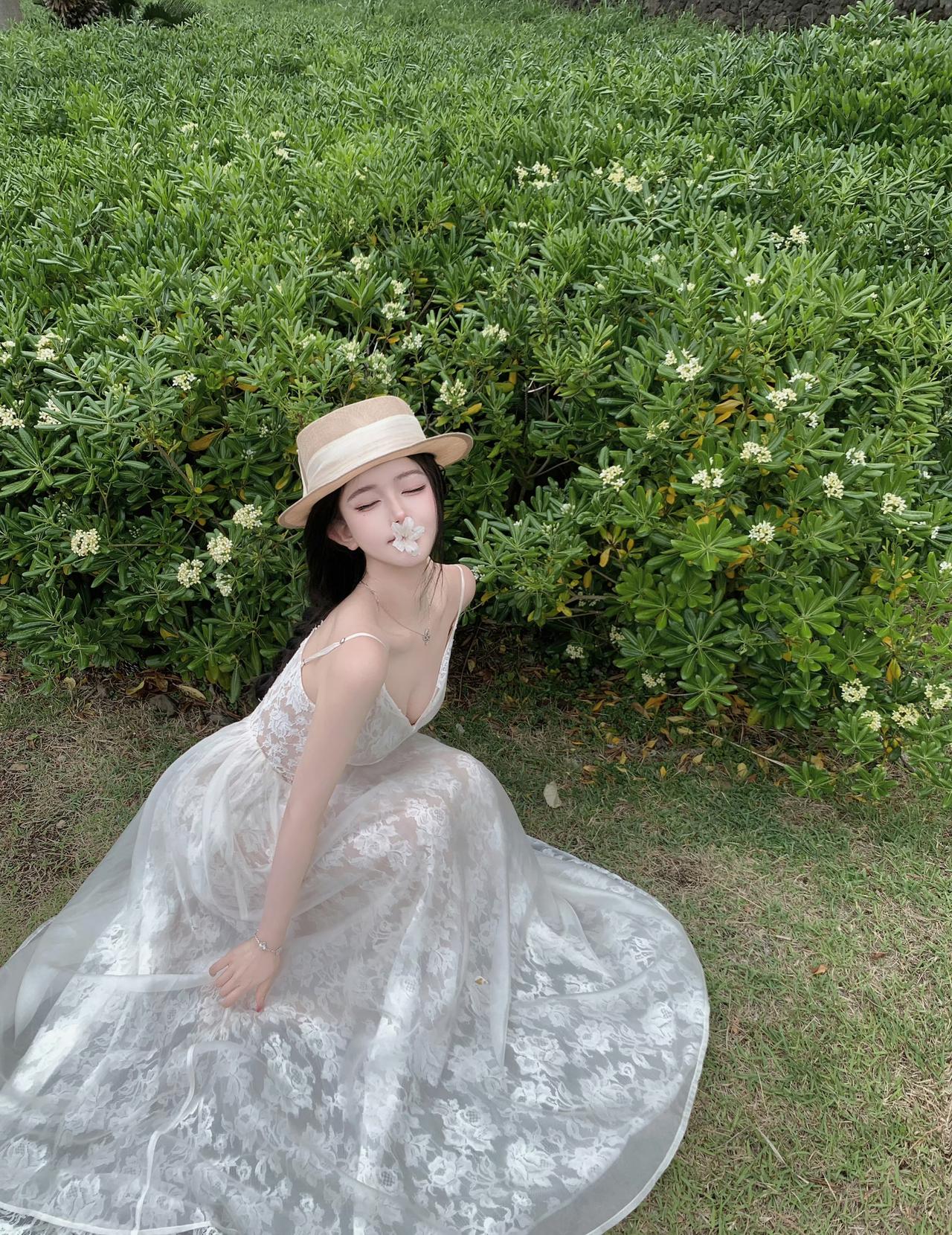 此地意境非常美，海边的木栈道、茂密的绿植以及你身上的白色蕾丝裙和草帽，营造出了一