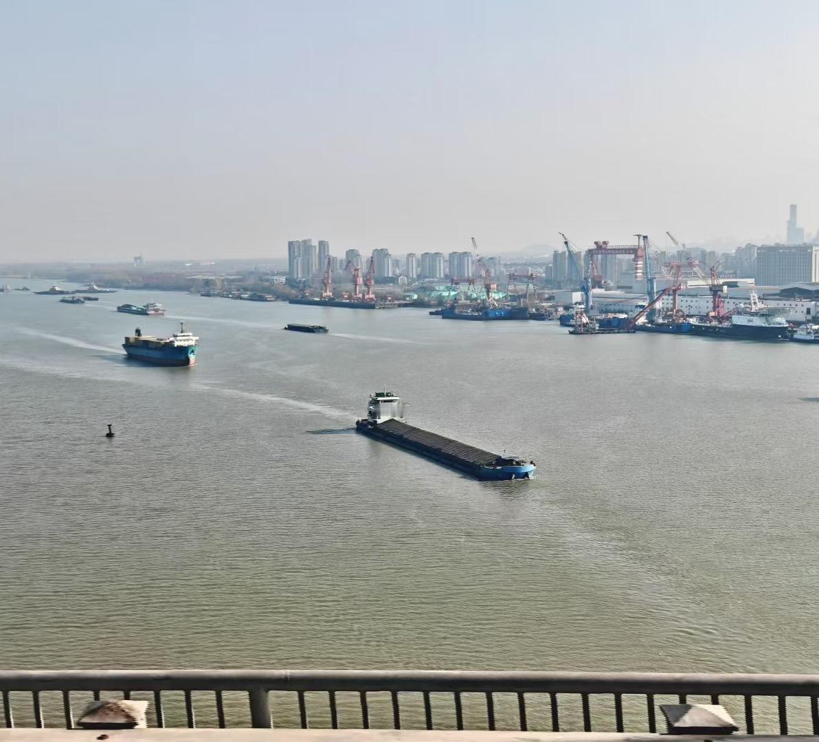 🚢 江水驮着船影流向远方，岸边长臂起重机像沉默的巨人，守着城市与潮汐的对话。