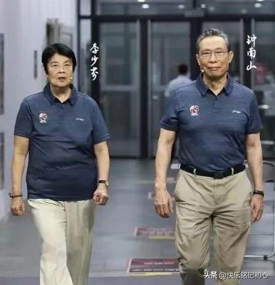 钟南山院士与夫人李少芬幸福同框 ，两人都穿着藏兰色T恤，卡其色长裤，夫人李少芬一