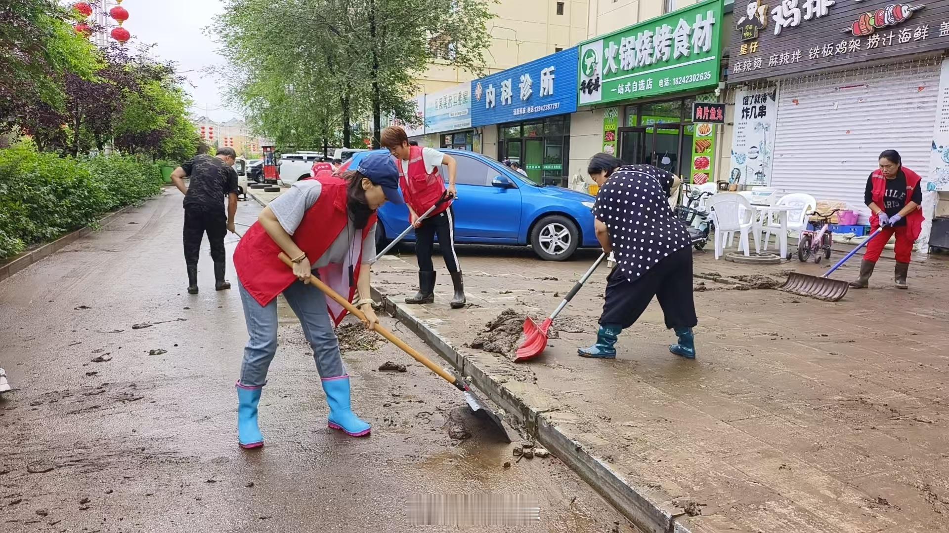 抚顺清原干群同心筑牢防汛防线 暴雨过后路面淤泥积水堆积，清原县清原镇浑南社区志愿