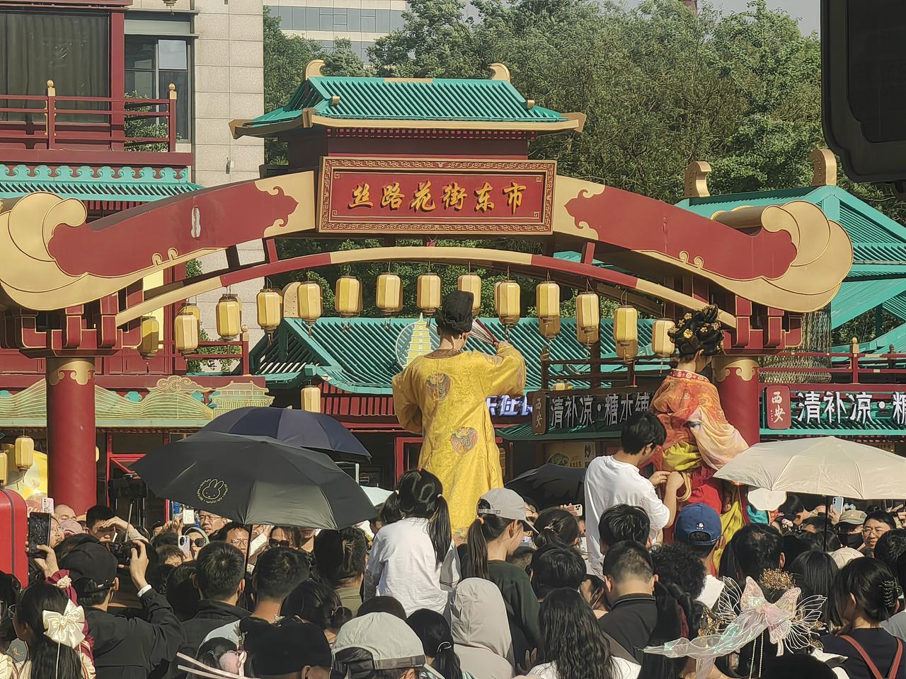 “五一”期间，气温适宜，二十几度，人们去西安大唐不夜城游览。这里人山人海，许多人