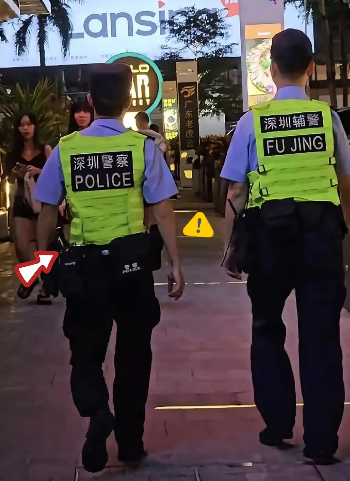 深圳，开了先河。
深圳街头，两名警察在街道上巡逻，一个警察的背心上标着深圳警察，