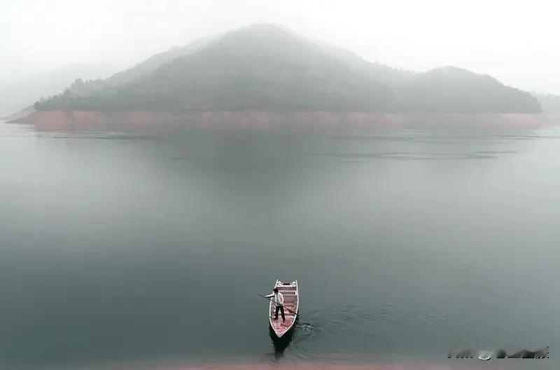 翻了翻相册里的山水照片，每一张都藏着一段旅行回忆。有张照片里，孤舟逐浪而去，远处